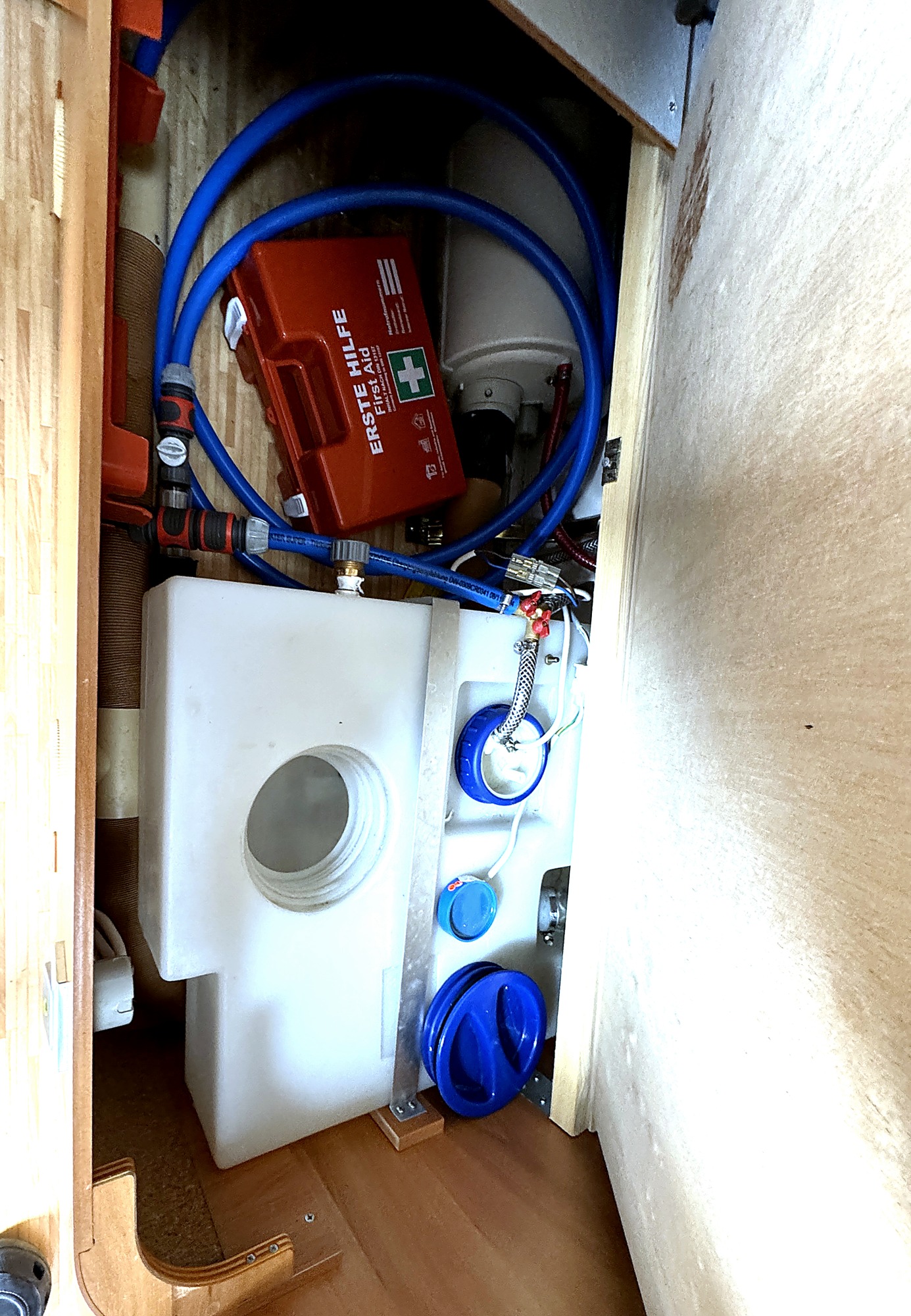 Stauraum unter dem Bett mit Frischwassertank, Boiler und Wasserleitungen.