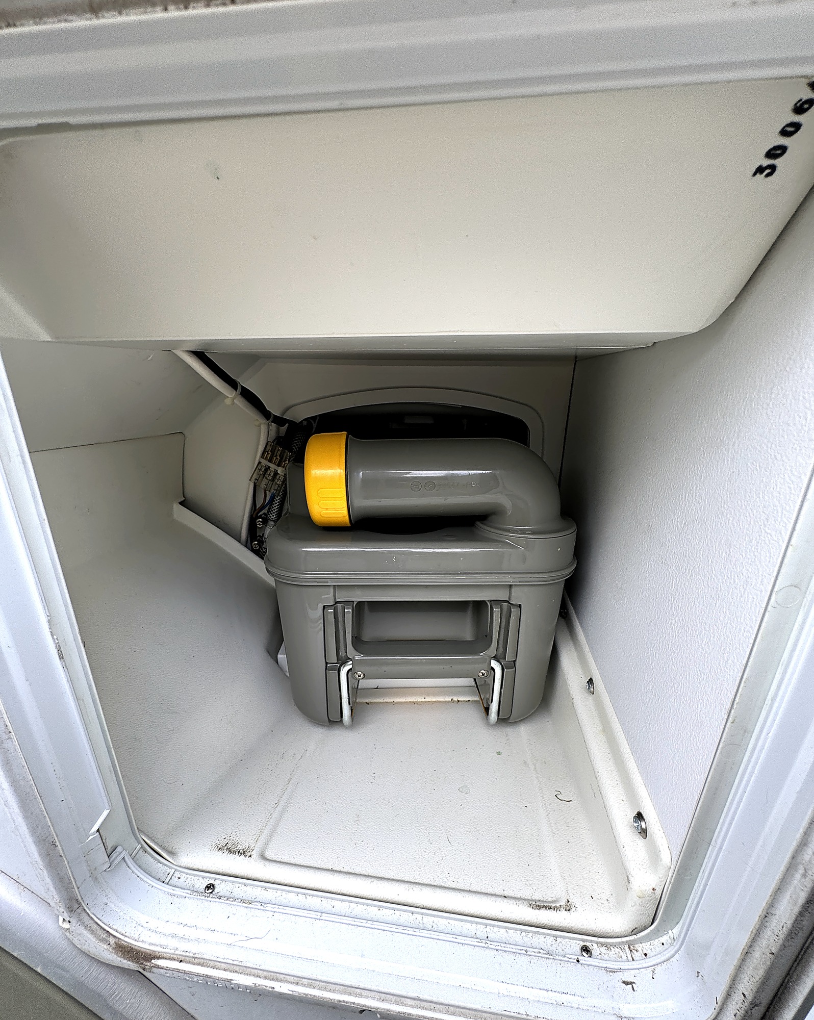 Serviceklappe mit eingesetzter Thetford Kassettentoilette – Gebrauchsspuren an der Dichtung sind zu sehen.